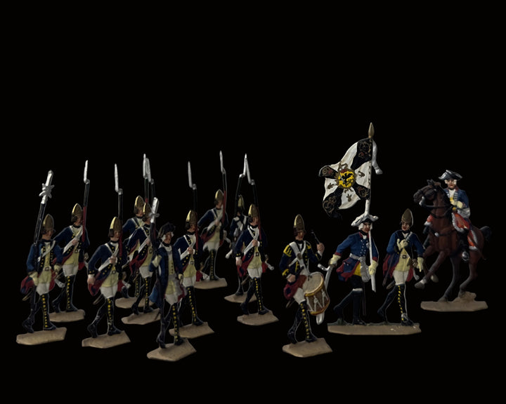A set of hand-painted historical military toy figures, including soldiers in blue and gold coats with red accents, a drummer, a flag bearer, and a mounted rider on a brown horse, displayed against a neutral gray background.