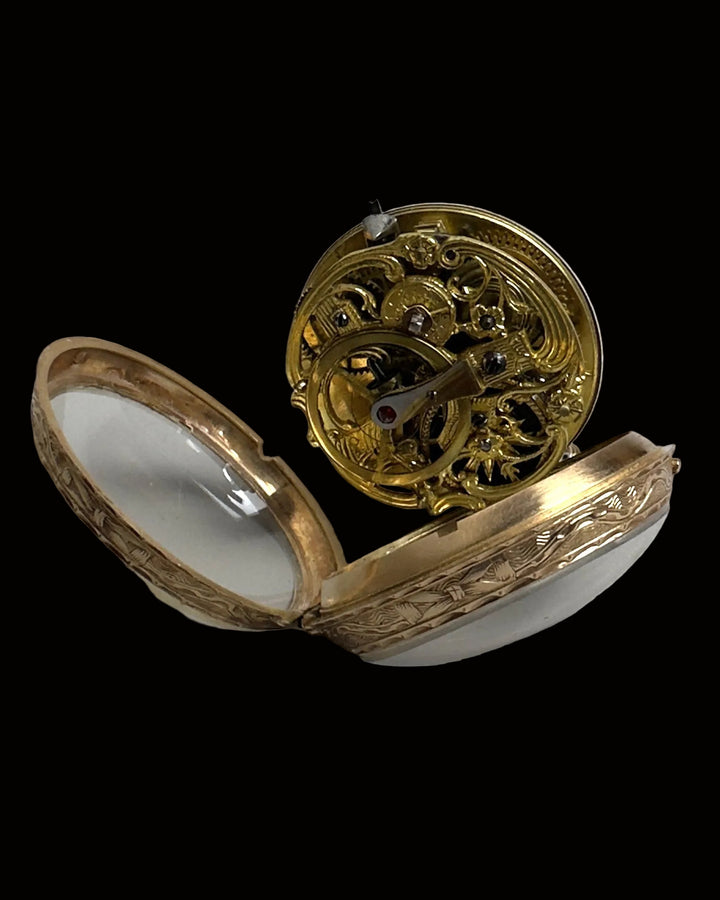 An antique gold pocket watch case shown open, displaying its intricate internal mechanical movement and engraved outer shell on a light gray background.