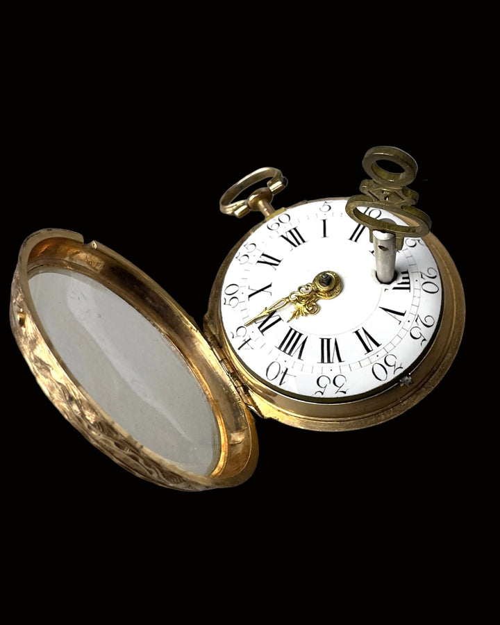 An antique gold pocket watch with its hinged cover open, showing a white dial with black Roman numerals and gold hands, photographed on a plain gray background.