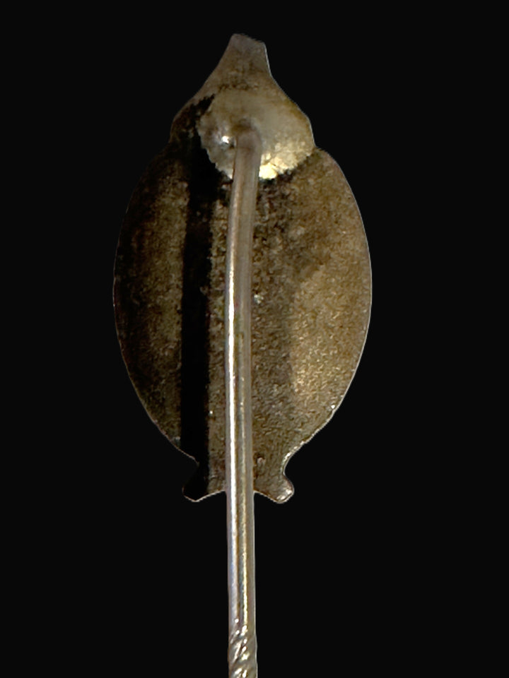 A vintage silver-toned metal hair pin or brooch with a textured, hammered finish, shown against a solid black background.