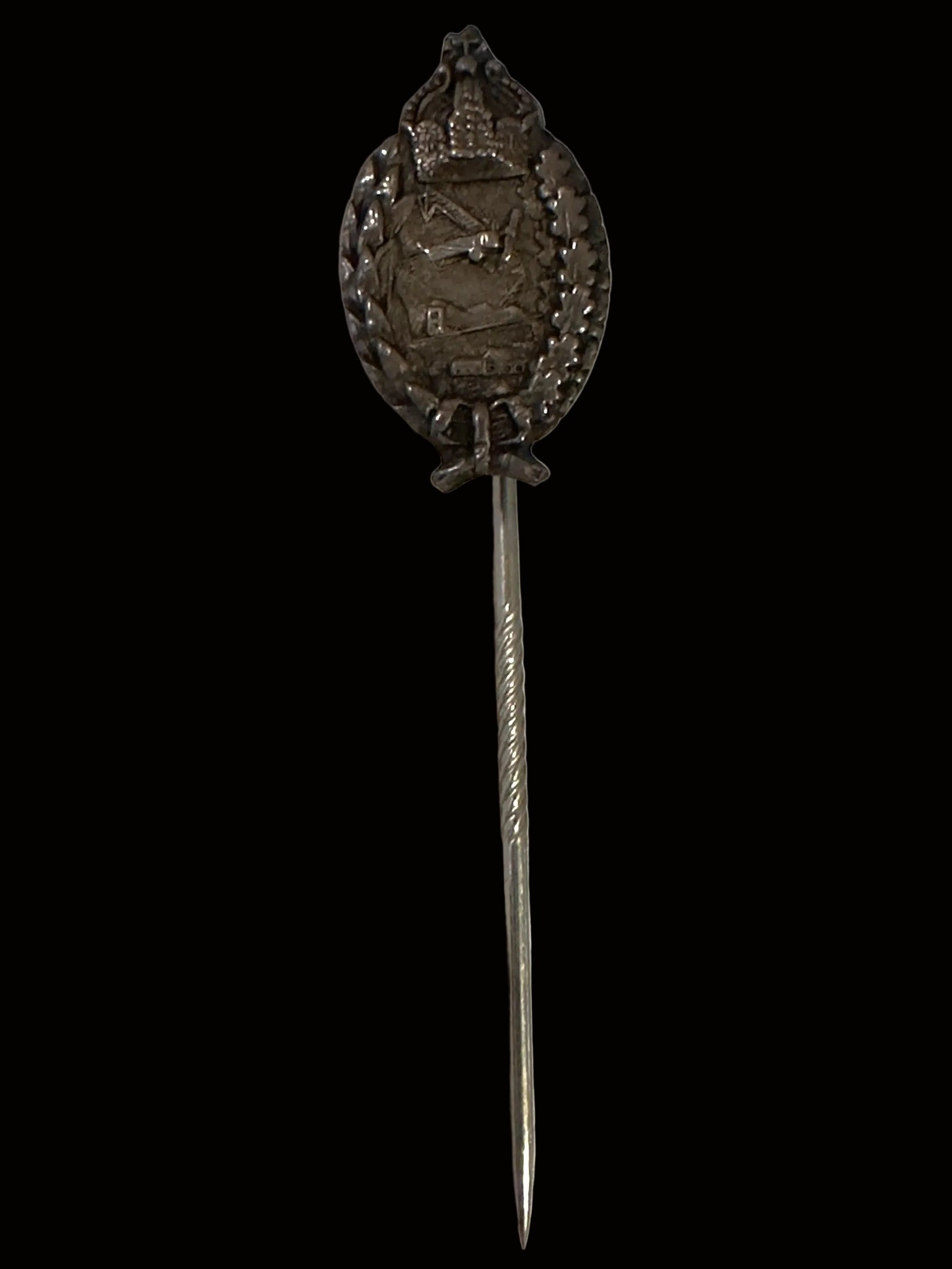 A vintage silver-toned metal lapel pin with an ornate shield emblem featuring a sword and crossed keys, mounted on a long straight pin, shown on a light textured background.